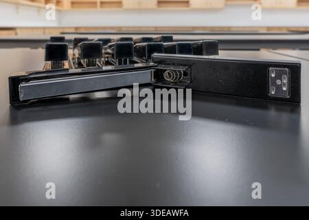 Close-up image of a open stapler on its side, with a organized group of staplers behind. Stock Photo