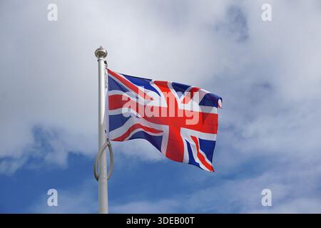 Flag of Great Britain flying in the wind. Union Jack flag of the United Kingdom. Stock Photo