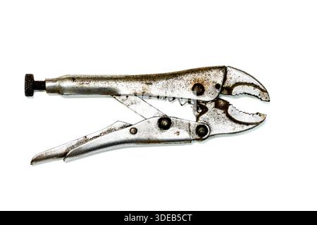 Worn locking pliers with rust and patina, isolated on white background. Adjustable metal hand tool used for gripping, clamping, and repair work. Stock Photo