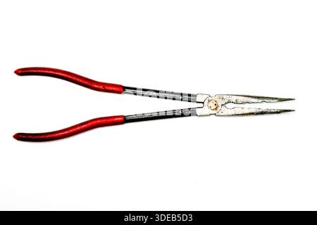 Used long nose pliers with red handles, isolated on white background. Precision hand tool for gripping, bending wire, and repair tasks Stock Photo