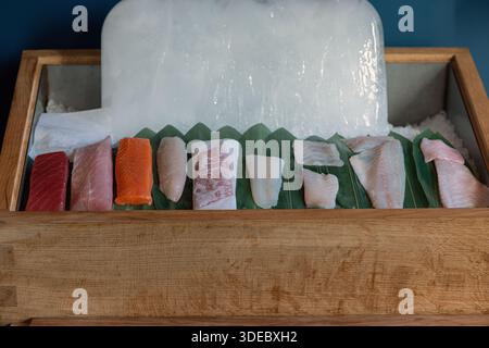 Close up of a traditional fish counter display at a Japanese restaurant, showcasing an assortment of fresh fish and seafood arranged on ice Stock Photo