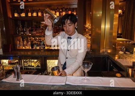 Bartender shakes a cocktail at the elegant bar of Tobi Masa, the exclusive Japanese restaurant within The Chancery Rosewood Hotel in London's Mayfair . Stock Photo