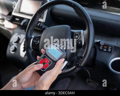 Woman using OBD2 diagnostic scanner.  Stock Photo