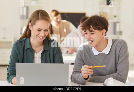 Happy smiling team of two young college friend students brainstorming working online in pairs Stock Photo