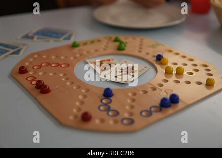 Travel romania transilvania targu mures people playing a wooden board game with colorful pieces and cards, enjoying leisure time Stock Photo