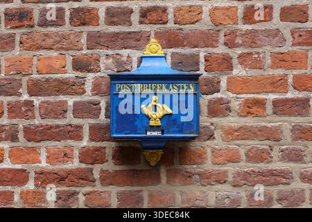 Traditional German post mailbox mounted on a brick wall in Bremen, Germany. Stock Photo