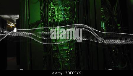 Moving dotted white light trail crossing server aisle, lighting racks, cable bundles and green LEDs Stock Photo