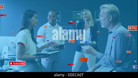Discussing team of four in smart dress reviewing displays in office, with tablet and overlay icons Stock Photo