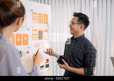 UX/UI designers collaborating during a creative workshop to test interface ideas and exchange feedback for app development, emphasizing teamwork and i Stock Photo