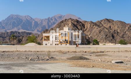Luxury Traditional Omani Villa Against the Rugged Hajar Mountains in Oman Stock Photo