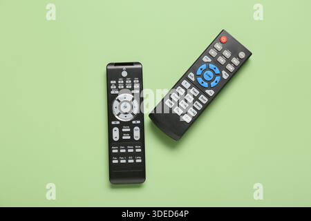 Different modern TV remote controls on green background Stock Photo