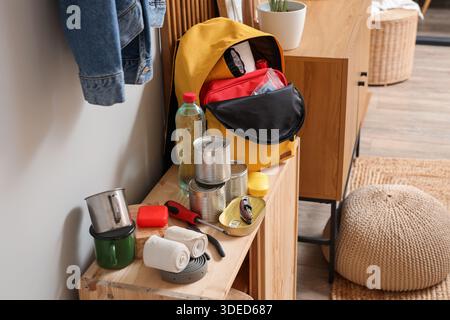 Emergency backpack with necessities on shelf in hallway Stock Photo