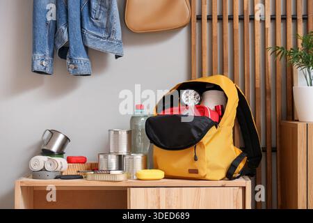 Emergency backpack with necessities on shelf in hallway Stock Photo