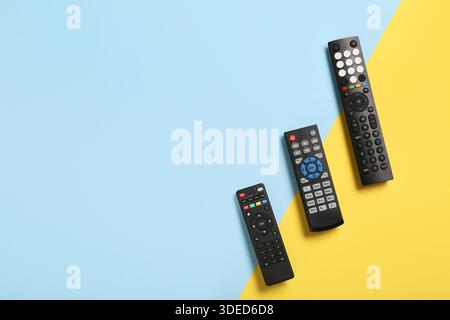Different modern TV remote controls on color background Stock Photo