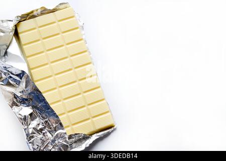 White chocolate bar with foil wrapper isolated on white background. Overhead view. Copy space. Stock Photo