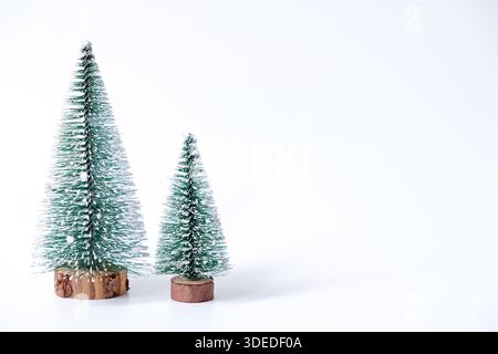 Miniature winter pine trees with snow. Festive christmas and holiday atmosphere, isolated on white background Stock Photo