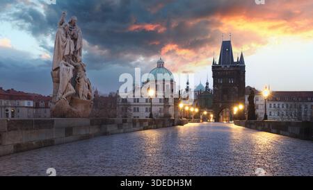 Charles Bridge over River Vltava at dramatic sunrise in Prague, Czech Republic, Europe Stock Photo
