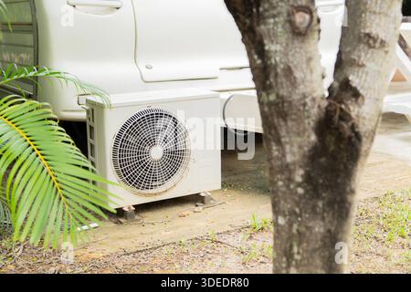 An air conditioner compressor unit  installed on the outside of the RV accommodation in a resort. Selective focus. Stock Photo