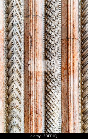 Close-up of ornate architectural columns with intricate patterns and textures, showcasing a mix of stone and marble finishes Stock Photo