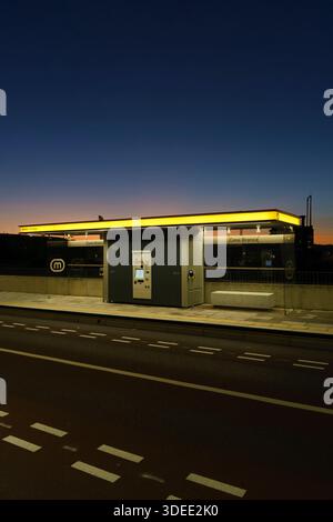 Modern metro bus stop with illuminated ticket machine on an empty street at dusk in Coimbra, Portugal, Europev Stock Photo