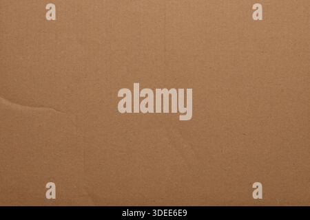 Surface of brown cardboard shows lines and textures in soft light during the day. Highlights material's details. Stock Photo