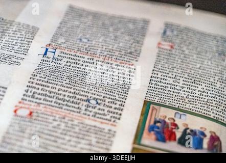 Close-up of ancient manuscript pages with handwritten text and colorful illustrations Stock Photo