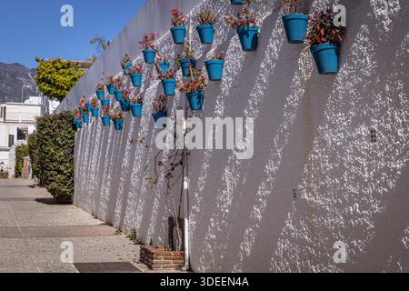 Pots of geraniums hanging on a white wall, with mountain view, Marbella, Spain Stock Photo