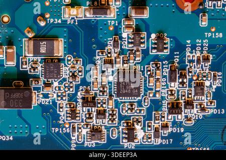 Macro image of motherboard showing integrated circuits and electronic components forming intricate conductive pathways for system performance. Stock Photo