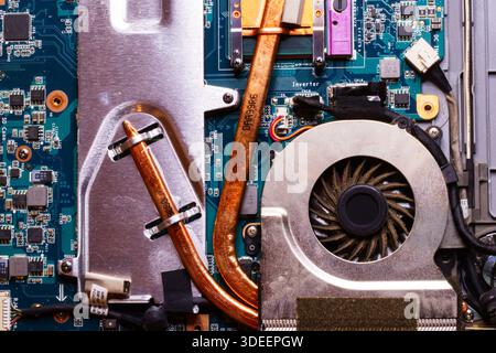 Internal view of laptop computer showing motherboard memory cooling fan and copper heat pipes used for temperature regulation and processing. Stock Photo