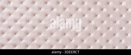 Pastel beige leather texture with capitone pattern, macro background of cream retro Chesterfield vintage textile fabric. Stock Photo