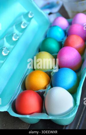 Turquoise carton holds a dozen brightly dyed Easter eggs. Stock Photo