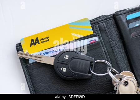 London. UK- January 05.2026. An AA roadside vehicle assistance membership card and a driving licence in a purse with a car key on top. Stock Photo