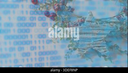 Mixing worn wooden star on pale blue backdrop, 0 or 1 code overlay, glitch, red berries, green sprig Stock Photo