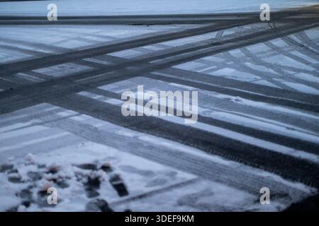 The tracks of car tires on the freshly fallen snow in the streets of Paris Stock Photo