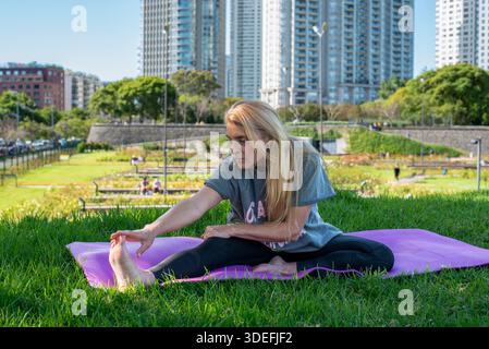 Focused woman working on her flexibility during an outdoor fitness session Stock Photo