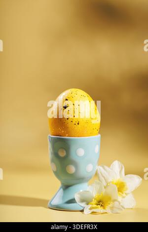 Vertical Easter card design with egg and daffodils on yellow background Stock Photo