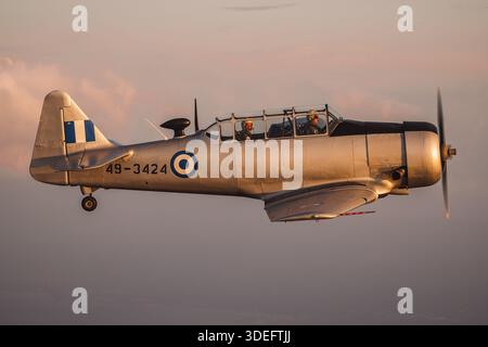 The North American T-6G Texan, Reg. 49-3424, Serial 168-548, is captured in close-up pilot view during air-to-air flight at Athens Flying Week 2025. This two-seat, single-engine trainer features a Pratt & Whitney R-1340 radial piston engine, tandem cockpit, tailwheel landing gear, and advanced flight controls. The aircraft is used for pilot training, aerobatic demonstrations, and historical flight displays. The image emphasizes cockpit instruments, pilot handling, and maneuvering capability in a demonstration flight. Stock Photo