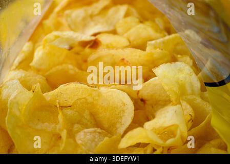Crispy golden potato chips in packaging. The Concept of Unhealthy Eating. Stock Photo