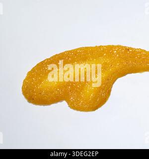 Smears of orange or yellow body scrub isolated on white. Stock Photo