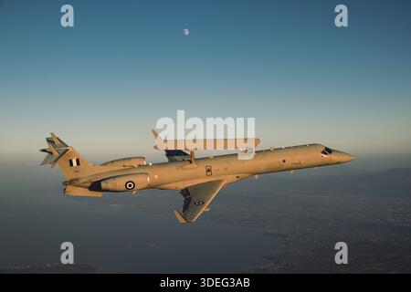 The image depicts a Hellenic Air Force Embraer EMB-145H AEW&C aircraft with Erieye radar flying air-to-air during Athens Flying Week 2025. Aircraft registered 729, serial 145729, part of 380 Mira Squadron. Twin-engine, Rolls-Royce AE 3007A turbofan, pressurized fuselage, dorsal radar, wing fuel tanks, tail vertical stabilizer. The photograph emphasizes airborne surveillance, early warning operations, and operational performance during air-to-air display flight. Stock Photo