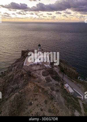 Aerial view of a lighthouse perched on a rugged rocky cliff overlooking ...