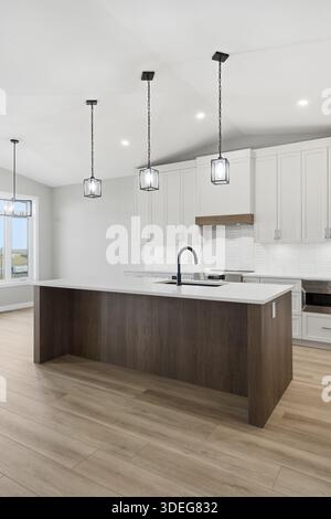 Kitchen with a wooden island and a sink. The kitchen is clean and well-lit. Scene is calm and inviting Stock Photo