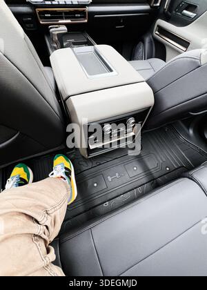 Ternopil,Ukraine - November 29, 2025: Passenger relaxes in the back seat GMC Hummer EV convertible with a center console and floor mats visible clearl Stock Photo