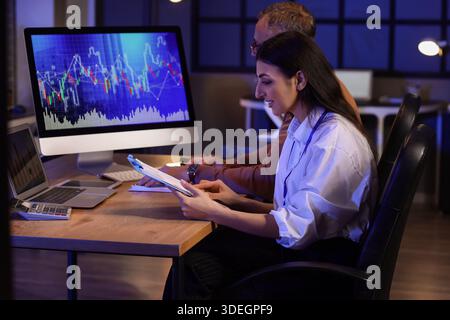 Business analysts working in office at night. Data science concept Stock Photo