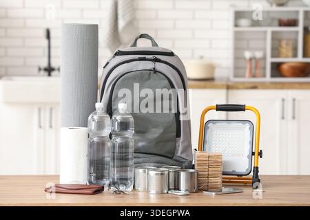 Emergency backpack with necessities on table in kitchen Stock Photo