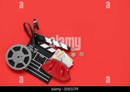 Wallet with money, movie clapper and film reel on red background Stock Photo