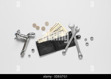 Wallet with money and plumber's tools on white background Stock Photo