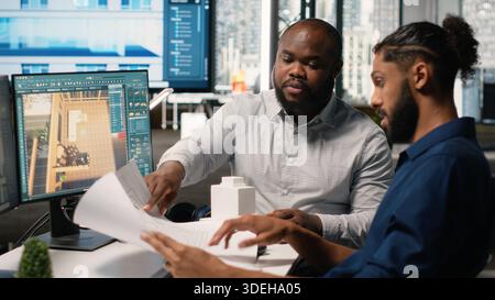 Engineer and designer working together on real estate interior design, using software for professional layout and structure. Creating master plans and reviewing construction blueprints. Stock Photo