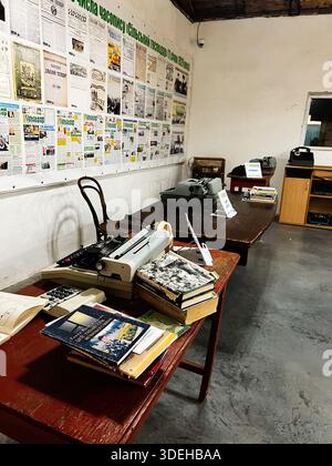Khodakhkiv,Ukraine - November 29, 2025: A retro office scene with typewriters, wall of newspapers, and book stacks on a wooden table. Stock Photo