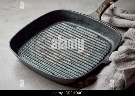 empty grill pan and linen towel on grey table top background Stock Photo